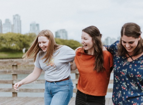 Τρεις κοπέλες αγκαλιασμένες γελάνε