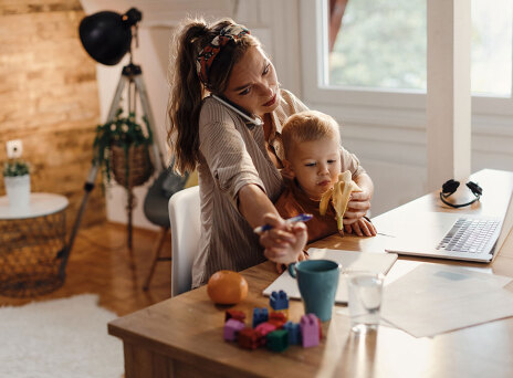 Γυναίκα μιλάει στο τηλέφωνο και κρατάει παιδί