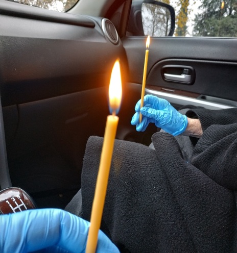 Χέρια που κρατούν αναμμένα κεριά μέσα σε αυτοκίνητο