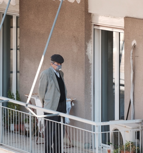 Ηλικιωμένος που φοράει μάσκα στο μπαλκόνι του