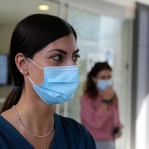 Γυναίκα φορά μάσκα προστασίας από τον κορωνοϊό σε εσωτερικό χώρο