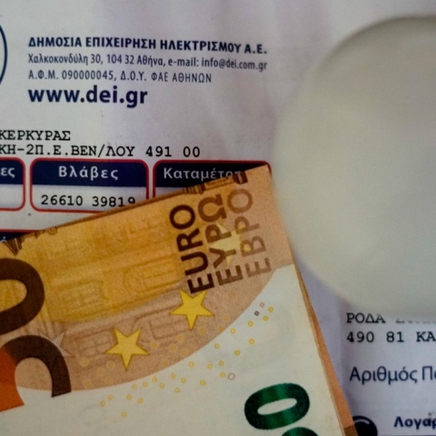 Λογαριασμός της ΔΕΗ με χαρτονόμισμα των 50 ευρώ και μία λάμπα