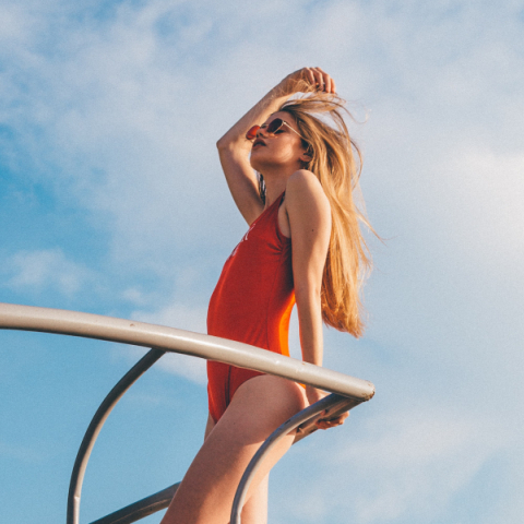 Ξανθιά κοπέλα, με κόκκινο μαγιό, πάνω σε σκάφος