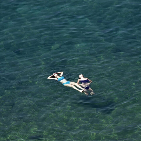 Λουόμενες στην παραλία απολαμβάνουν τη θάλασσα