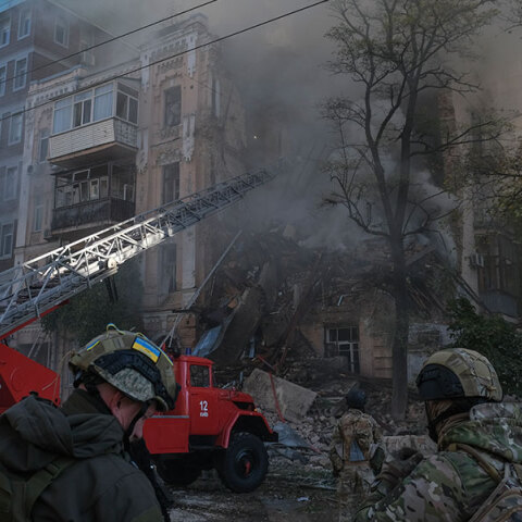 Διασώστες μπροστά σε βομβαρδισμένη πολυκατοικία στο Κίεβο μετά τη ρωσική επίθεση με drone