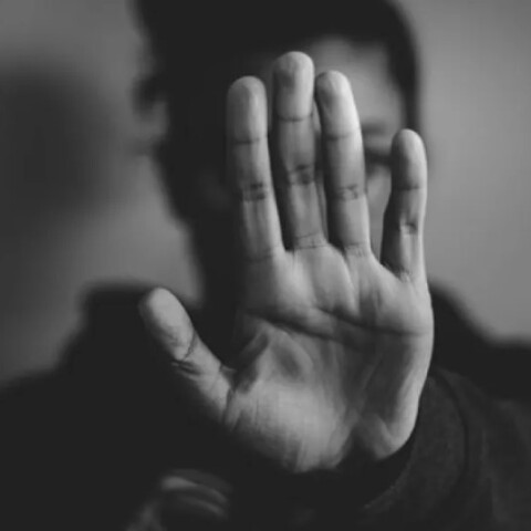 Γυναίκα κρύβει με το χέρι της το πρόσωπό της