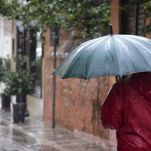 Πολίτης με ομπρέλα προσπαθεί να προστατευτεί από τη βροχή