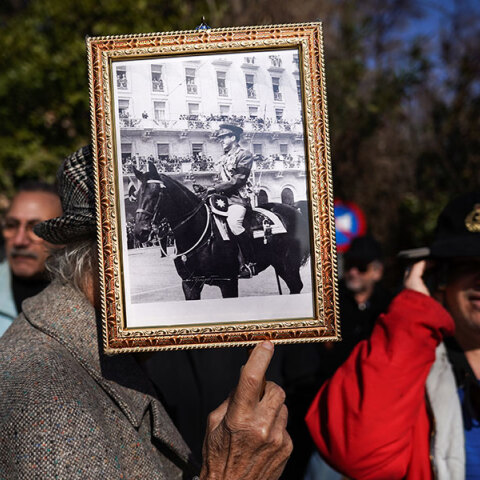 Πολίτης έξω από τη Μητρόπολη Αθηνών με φωτογραφία του τέως βασιλιά Κωνσταντίνου