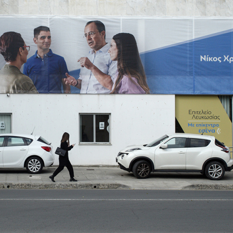 Μια γυναίκα περπατά μπροστά από το προεκλογικό κέντρο του Νίκου Χριστοδουλίδη στη Λευκωσία