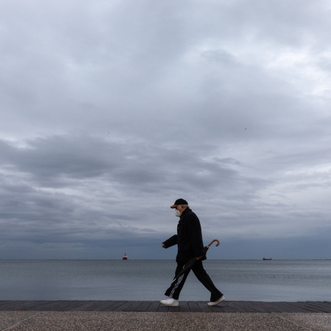 Συνταξιούχος περπατά σε παραλία