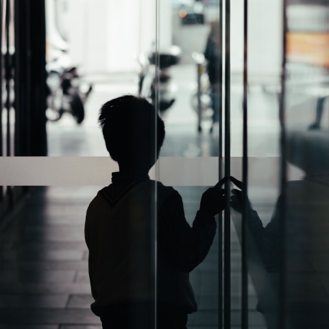 Παιδί σε σκοτεινό διάδρομο φαίνεται να φοβάται να βγει στο φως - Εικόνα που παραπέμπει σε κακοποίηση και bullying