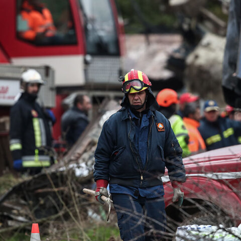 Πυροσβέστης στα Τέμπη με φόντο τα συντρίμμια μετά τη σύγκρουση τρένων