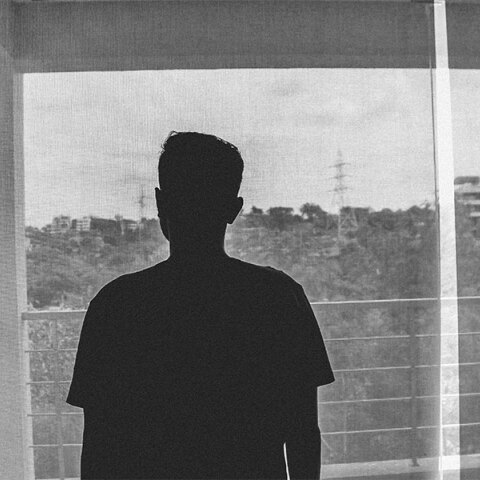 Έφηβος κοιτά από το παράθυρο