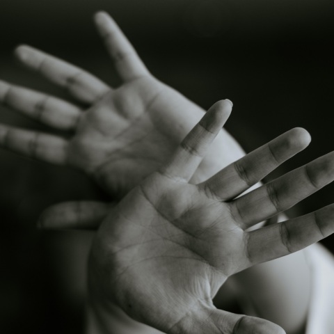 Άτομο με τα χέρια μπροστά στο πρόσωπο - Εικόνα που παραπέμπει στην ανάγκη το άτομα να προστατευτεί και να αποφύγει την επίθεση - κίνδυνο