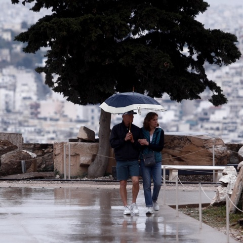 Ζευγάρι κάτω από την ομπρέλα προστατεύεται από τη βροχή