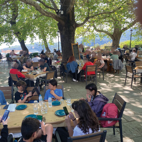 Παιδιά καθισμένα σε τραπέζι ταβέρνας με τα κινητά στο χέρι