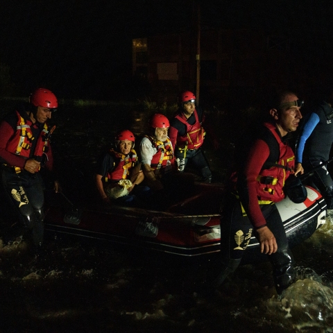 Ομάδα διασωστών κουβαλάει με τη βάρκα ζευγάρι ηλικιωμένων