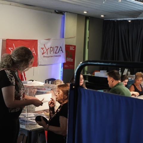 Μέλη του ΣΥΡΙΖΑ σε εκλογικό κέντρο παίρνουν το ψηφοδέλτιο και αναμένουν να ψηφίσουν 