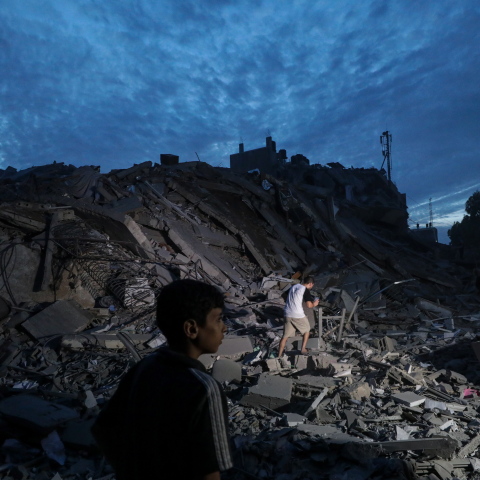 Παιδί περνάει μπροστά από κατεστραμμένο κτίριο στη Γάζα