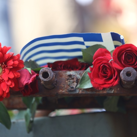 Λουλούδια και ελληνική σημαία στην ιστορική πύλη του Πολυτεχνείου