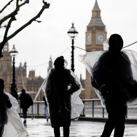 Κάτοικοι του Λονδίνου με αδιάβροχα μπροστά από το Παλάτι του Ουεστμίνστερ