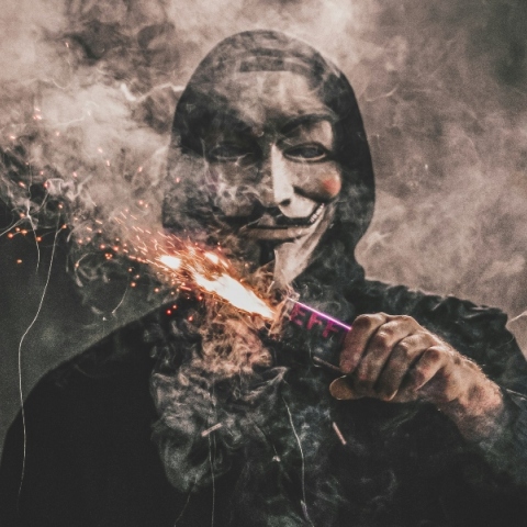 Άνδρας φορώντας μάσκα κρατάει φλεγόμενο πυρσό