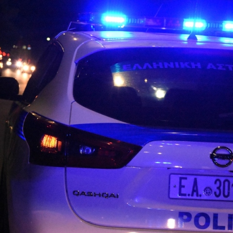 Λευκό περιπολικό τη νύχτα με μπλε φάρους