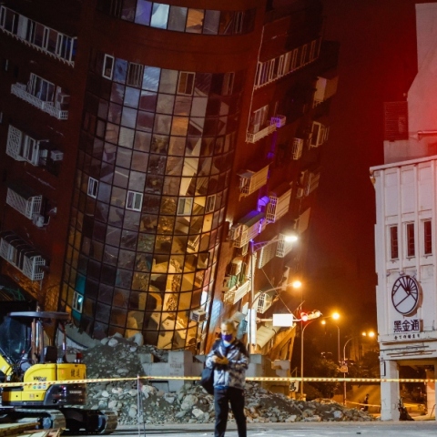 Μισογκρεμισμένη πολυκατοικία πίσω από άνδρα με μάσκα - μπάζα, κτίρια, εσκαφέας