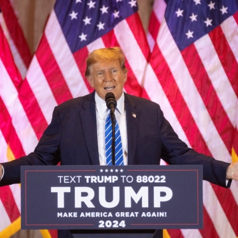 Ο Ντόναλντ Τραμπ, μιλάει όρθιος στο βάθρο - αμερικανικές σημαίες