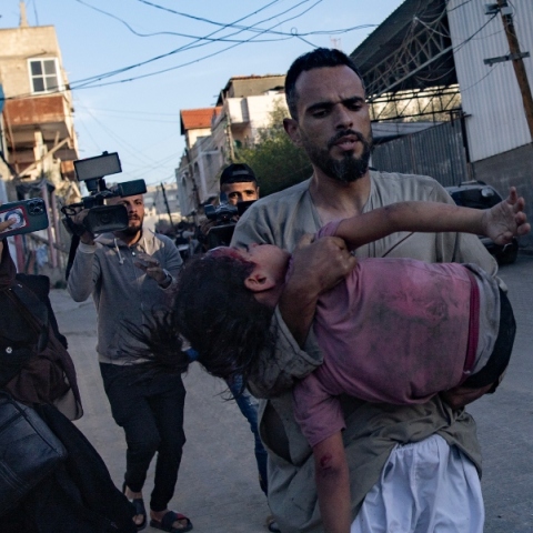 ανδρας κραταει τραυματισμένο παιδι