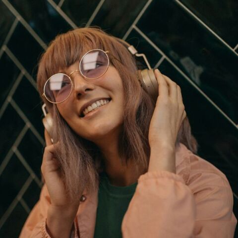 Μια νεαρή γυναίκα ακούει μουσική στα ακουστικά της