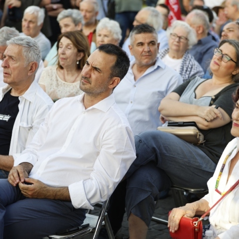 ο Αλέξη Χαρίτση καθισμενος αναμεσα σε κοσμο