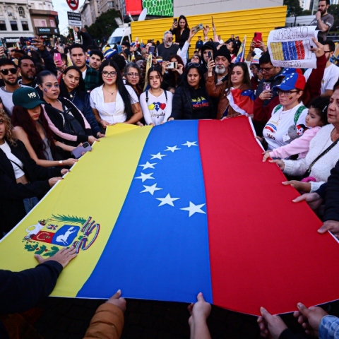 Διαδηλωτες κρατουν τη σημαια της Βενεζουελας