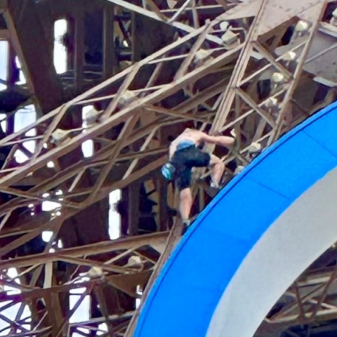 ανδρας σκαρφαλωνει τον πυργο του αιφελ