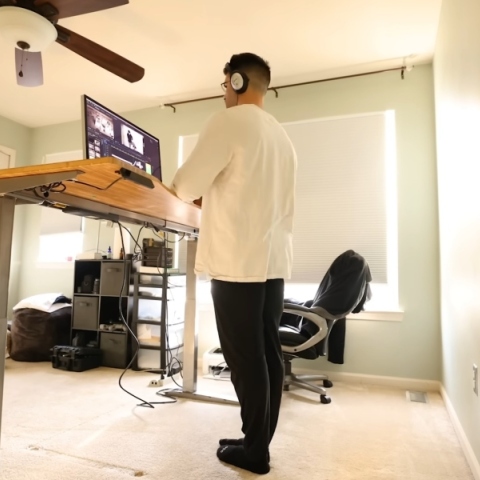 ανδρας εργαζεται ορθιος μπροστα σε γραφειο