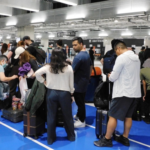 επιβατες περιμενουν στον ελεγχο αποσκευων αεροδρομιου