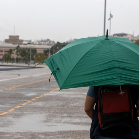 ανδρας περπαταει με ομπρελα