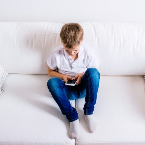 παιδι καθισμενο κραταει κινητο