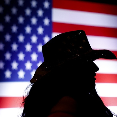 Γυναίκα με καπέλο μπροστά από την αμερικανική σημαία