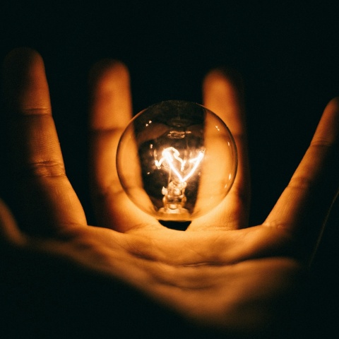 Αναμμένη λάμπα σε χέρι ατόμου