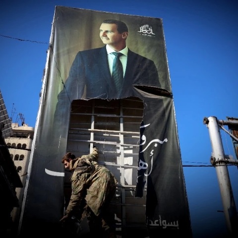 Τζιχαντιστής σκίζει αφίσα του Σύριου πρόεδρου, Μπασάρ αλ Άσαντ στο Χαλέπι