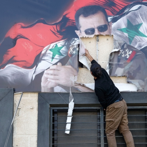 Κάτοικος της Συρίας σχίζει αφίσα του Άσαντ στη Δαμασκό