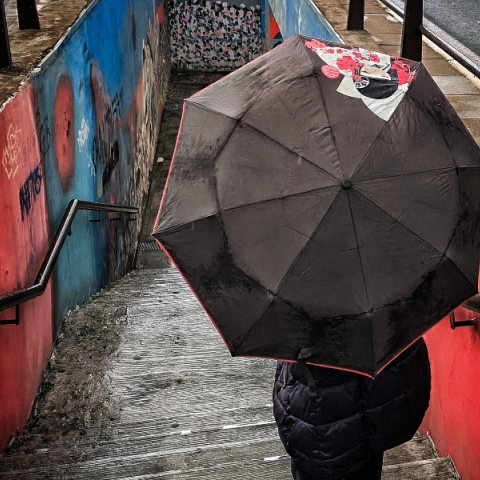 ανθρωπος με ομπρελα κατεβαινει σκαλες