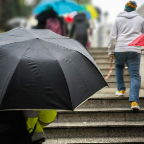 Πολίτες με ομπρέλες προστατεύονται από τη βροχή