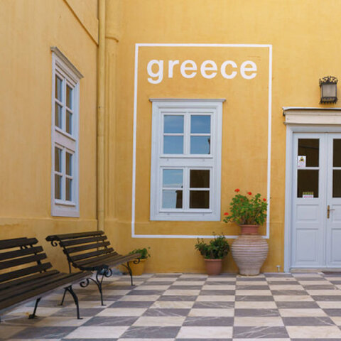 Άποψη της κεντρικής αυλής της Ιστορικής Οικίας Λαζάρου Κουντουριώτη με την τοιχογραφία που μετατρέπει παράθυρο της κεντρικής αυλής της Ιστορικής Οικίας Λαζάρου Κουντουριώτη σε τουριστική αφίσα