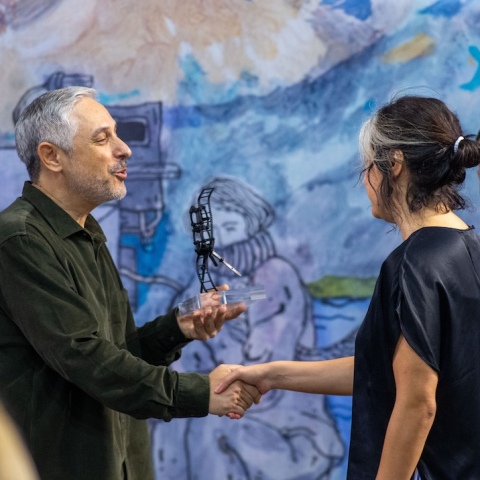 Ο Γιάννης Κατσούγκρης, Επικεφαλής Χορηγιών και Εκδηλώσεων της Αθηναϊκής Ζυθοποιίας, απονέμει το Βραβείο Κοινού Fischer Film Forward στη σκηνοθέτιδα της ταινίας Χίλια