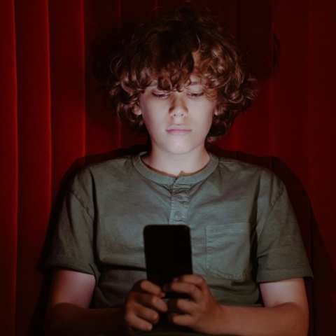 παιδι καθισμενο κραταει κινητο