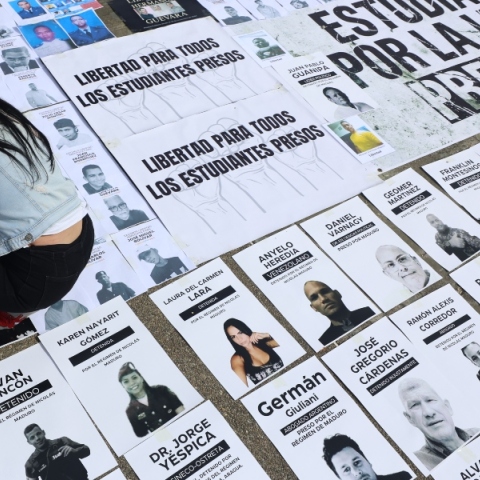 Ένα άτομο κοιτάζει εικόνες πολιτικών κρατουμένων κατά τη διάρκεια διαμαρτυρίας στην Plaza del Rectorado UCV στο Καράκας, Βενεζουέλα