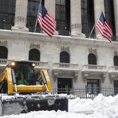 Εργάτες καθαρίζουν το χιόνι μπροστά στο γλυπτό «Το Ατρόμητο Κορίτσι» έξω από το Χρηματιστήριο της Νέας Υόρκης 