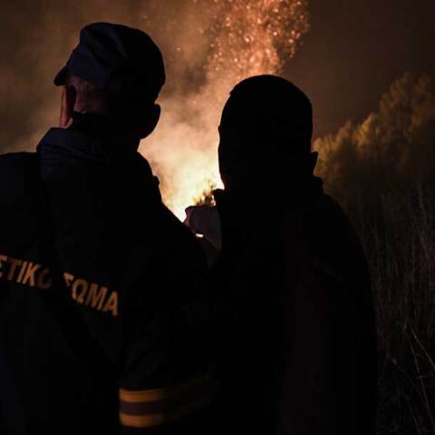 Πυροσβέστες μπροστά στις φλόγες κατά τη διάρκεια της νύχτας